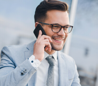 Man wearing a blazer talking over phone